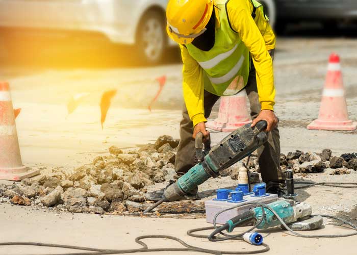 worker remove old driveway
